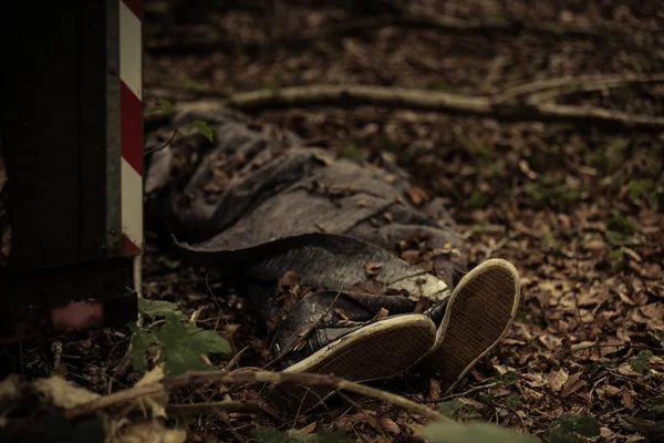 Lichaam van een dode persoon liggend in bos detritus — Stockfoto