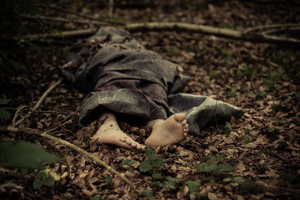 Dead body of a barefoot boy in the forest — Stock Photo, Image