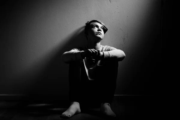 Barefoot thoughtful boy sat against wall — Stock Photo, Image