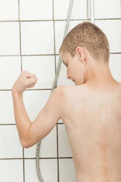 Ragazzino flettendo i bicipiti sotto la doccia — Foto Stock