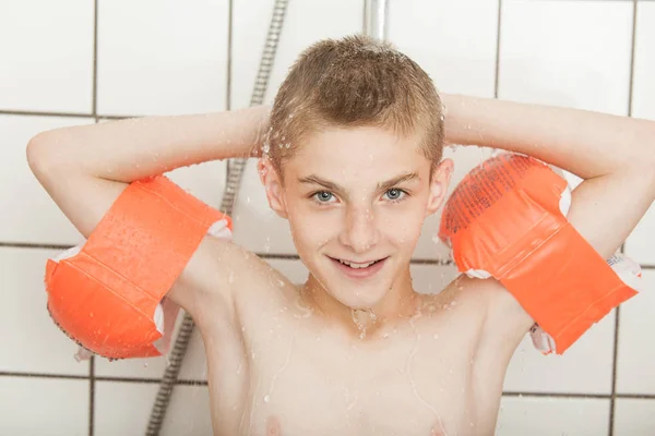 Niño pequeño con alas de agua roja en la ducha — Foto de Stock