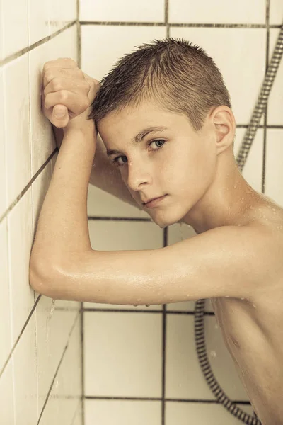 Niño introvertido tomando una ducha — Foto de Stock