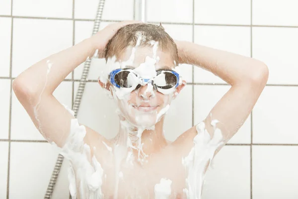 Cute little boy wearing goggles in the shower — Stockfoto