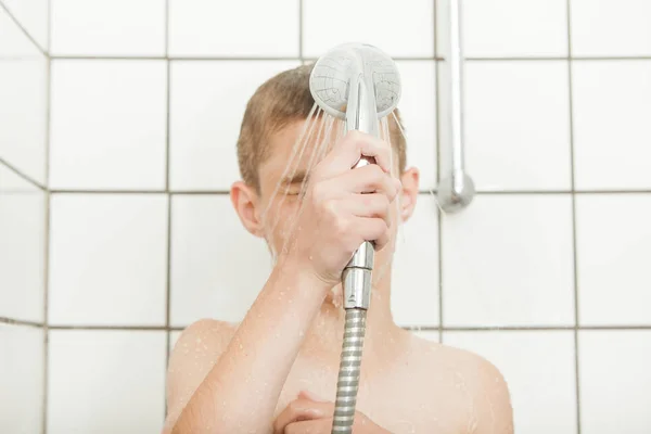 Joven enjuagándose la cara en la ducha — Foto de Stock