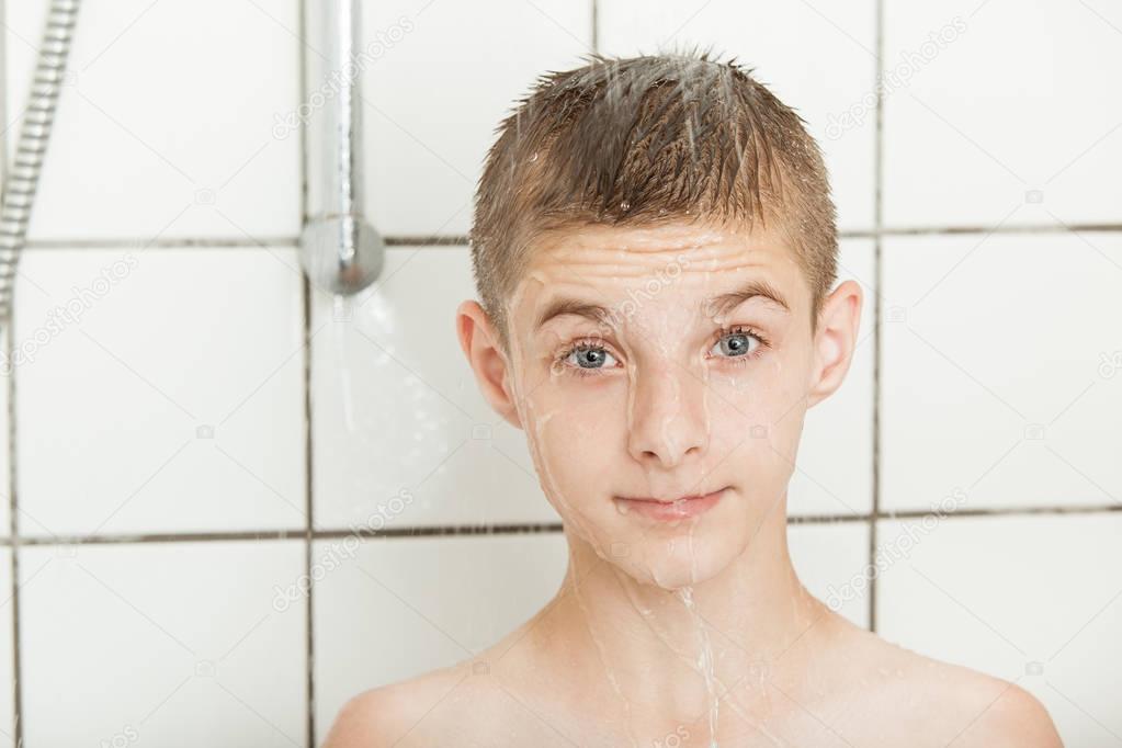 Cute surprised little boy showering