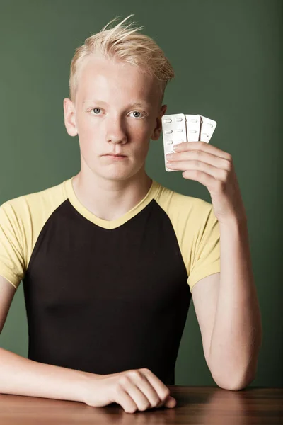 Young teenage boy holding up packs of tablets — Stock Photo, Image