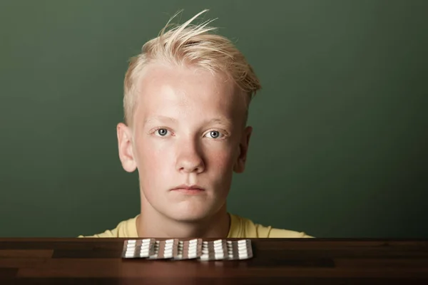 Zasmušilý blond dospívající chlapec s tablety v balení — Stock fotografie