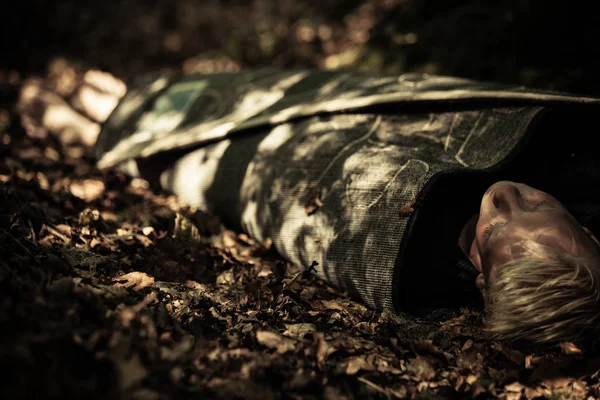 Мертве тіло хлопчика-підлітка лежить у лісі — стокове фото