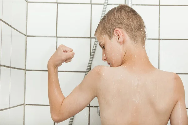 Single child flexing biceps in shower stall