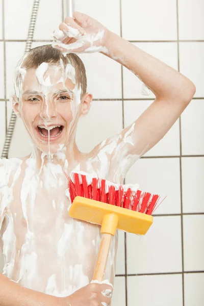 Niño feliz cubierto de jabón con cepillo de matorral grande — Foto de Stock