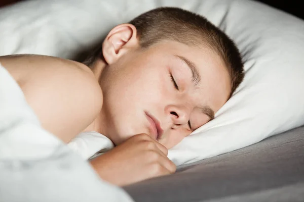 Cerca de niño dormido en la cama — Foto de Stock