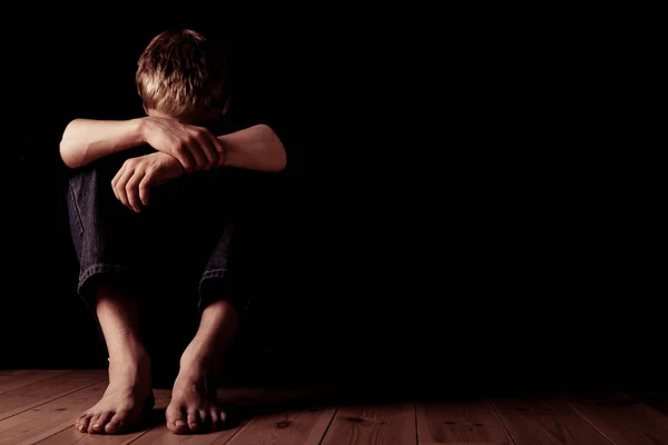 Young man sitting with arms over knees — Stock Photo, Image