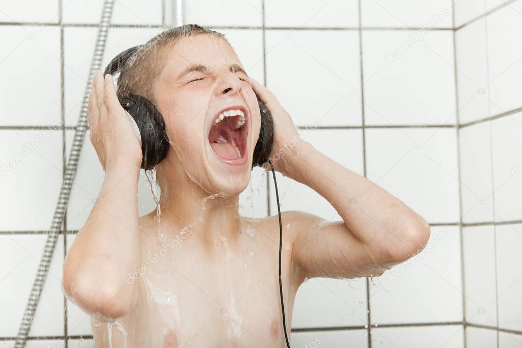 Singing child with earphones in shower stall