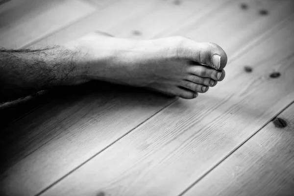 Primer plano en pie masculino sobre piso de madera — Foto de Stock