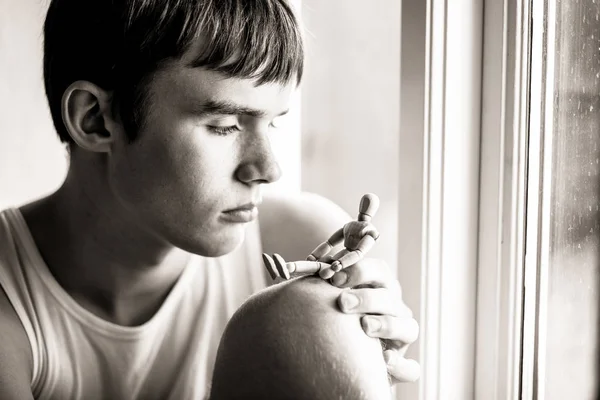 Ragazzo adolescente serio guardando manichino di legno — Foto Stock