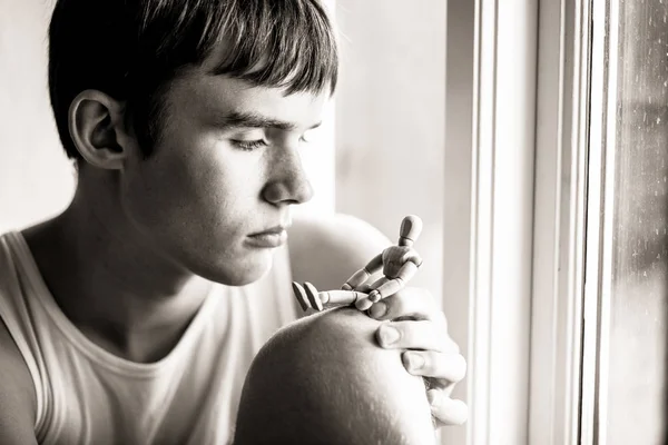 Sérieux adolescent garçon regarder en bois mannequin — Photo