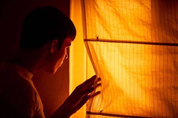 Jeune homme effrayé se tient à côté de la fenêtre — Photo
