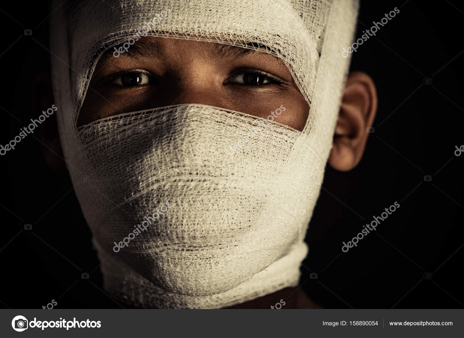 Young black boy with bandages on his face Stock Photo by