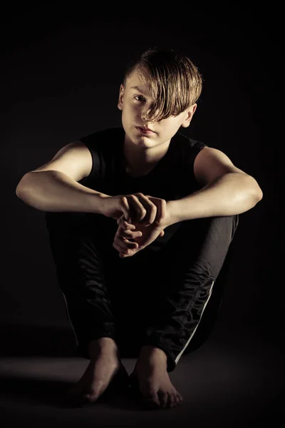 Deprimido adolescente sentado com os braços em torno de joelhos — Fotografia de Stock