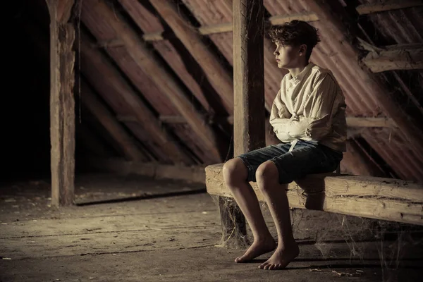 Teenage boy being kept captive in an attic — Stock Photo 