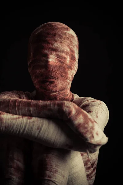 Strašidelné krevní pokecané mumie sedí ve tmě — Stock fotografie