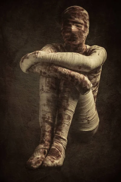 Soltera joven y sangrienta momia se sienta en la oscuridad — Foto de Stock