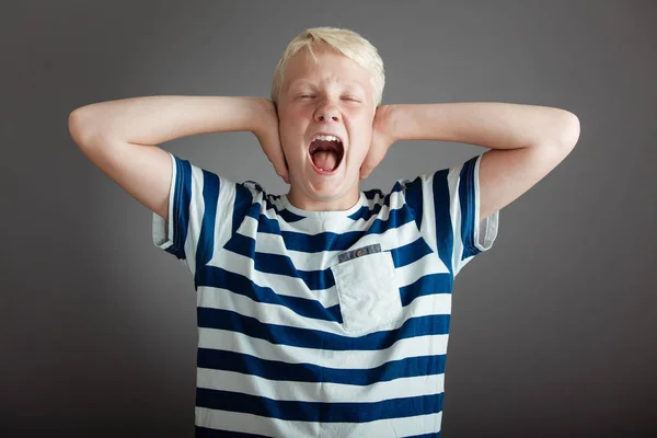 Skrikande blond tonåring med händer som täcker öron — Stockfoto