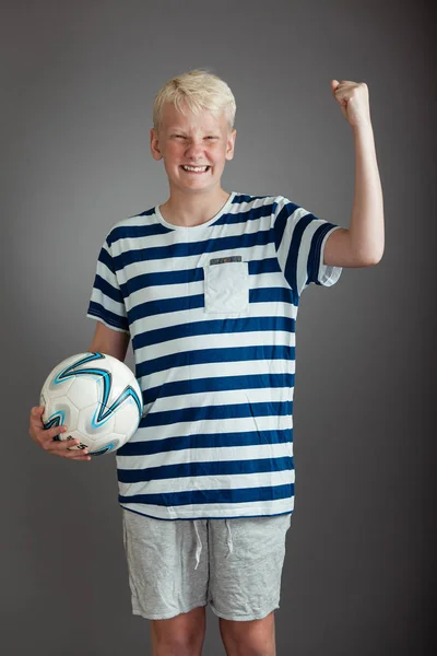 Blonde tiener in gestreepte shirt en broek met bal — Stockfoto