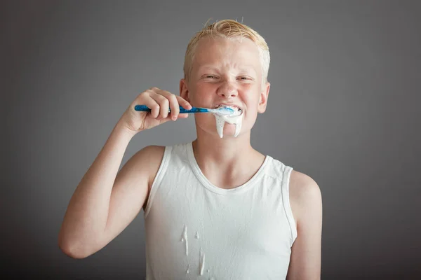 Lindo chico rubio cepillándose los dientes — Foto de Stock