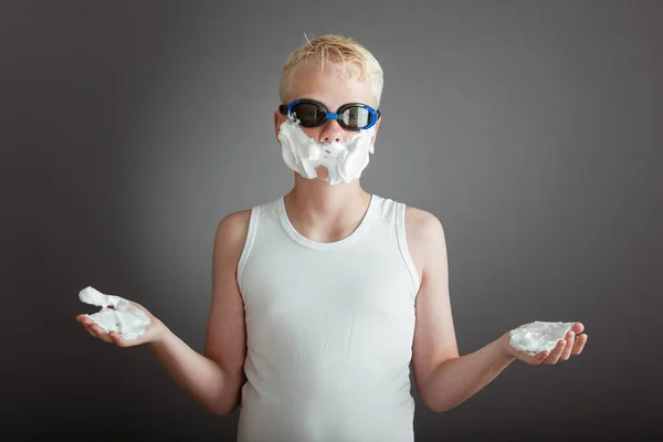 Enfant avec les mains et le visage plein de crème à raser — Photo