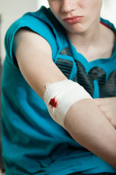 Close up on wounded elbow of teen boy