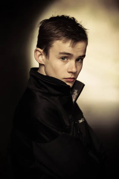 Sepia getinte foto van coy jongeman in zwarte jas — Stockfoto