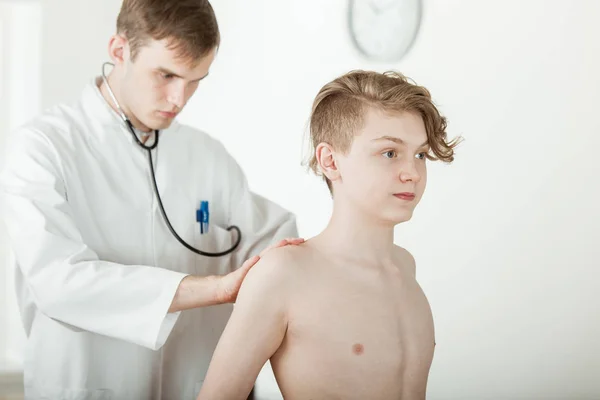 Doktor genç çocuğun sırt kasları incelenmesi