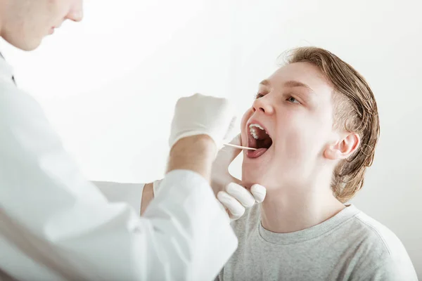 Adolescente ragazzo avendo bocca esaminata da medico — Foto Stock