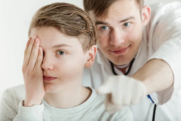 Dottore standing dietro giovanissima ragazzo durante visione test — Foto Stock