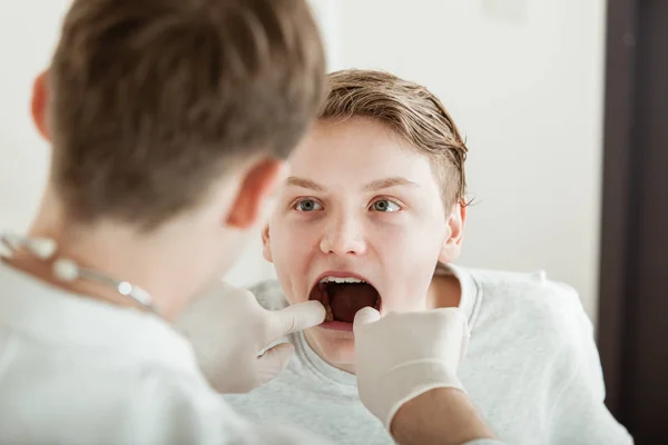 Adolescente chico teniendo boca examinado por doctor — Foto de Stock