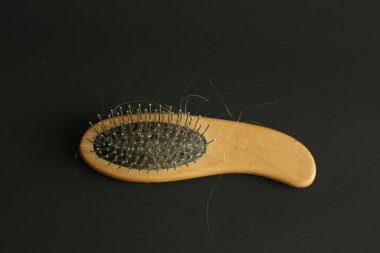 Saç dökülmesi sorunu saç fırçası siyah arka plan