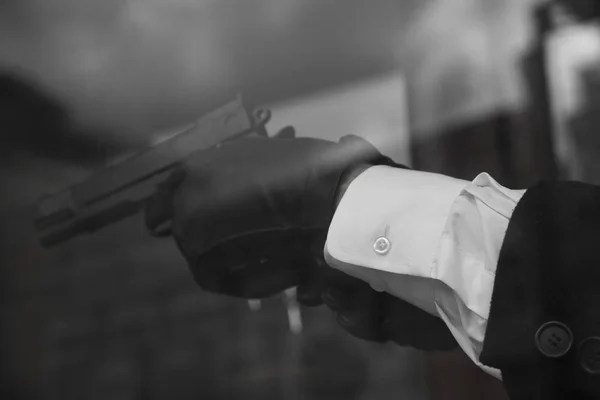 Pistola blanca camisa guantes negros —  Fotos de Stock
