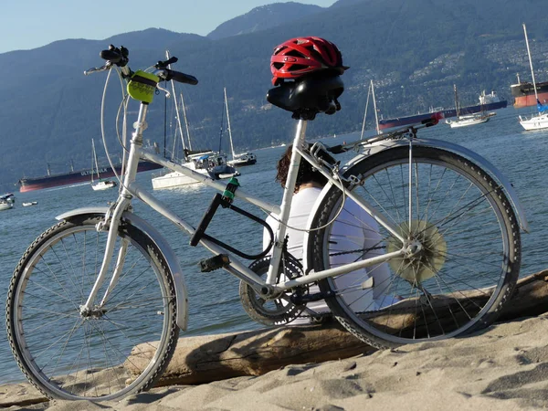 Feminino sentado perto de bicicleta oceano praia — Fotografia de Stock