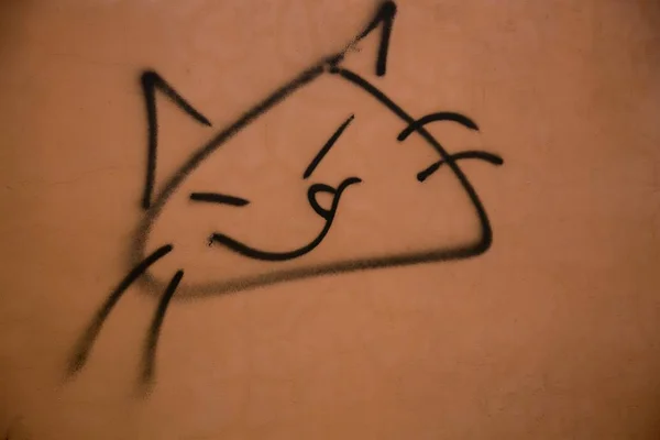 Черный мел рисует улыбающуюся стену кошачьего лица — стоковое фото