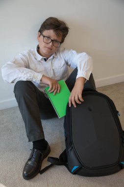 Backback okul üniforması oturan ciddi yakışıklı