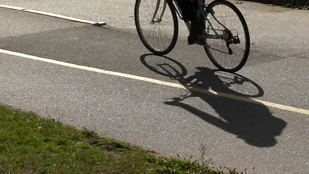 Bicyclist shadow moving on asphalt slow motion — Stock Video