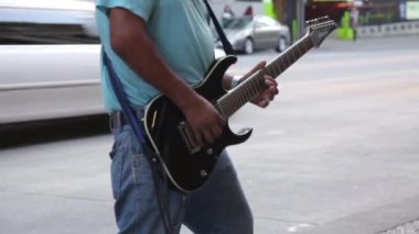 Müzisyen gitarist tarafından geçen sokak araba limosine oynarken