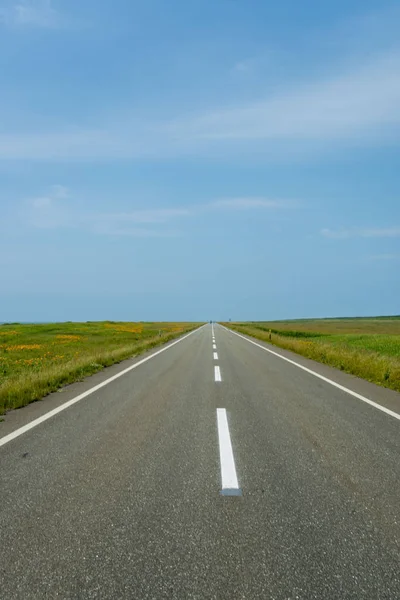 Uma estrada em linha reta com vista para o horizonte — Fotografia de Stock