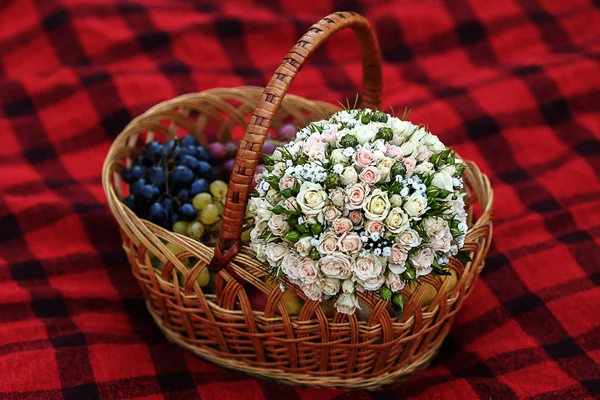 bouquet and different fruits in wicker basket