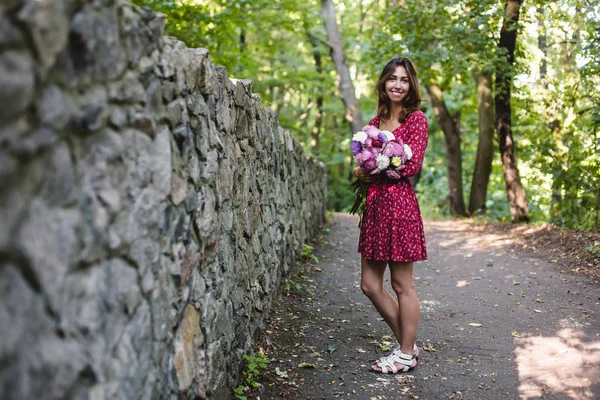 Giovane donna sorridente con fiori — Foto Stock