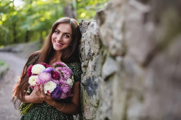 Giovane donna sorridente con fiori — Foto Stock