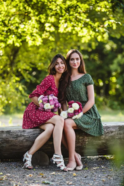Twee jonge vrouwen met bloemen glimlachen — Stockfoto