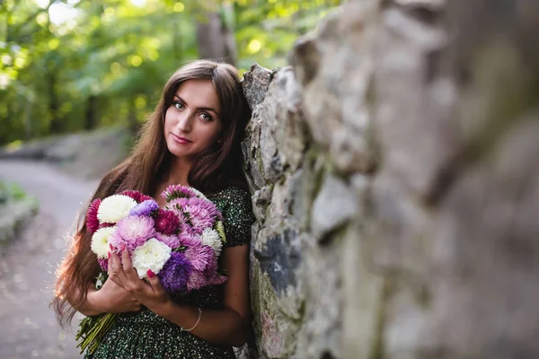 Mladá usmívající se žena s květinami — Stock fotografie