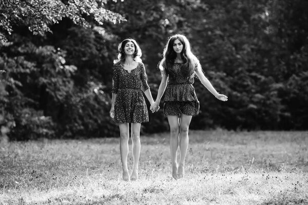 Two young smiling women levitate